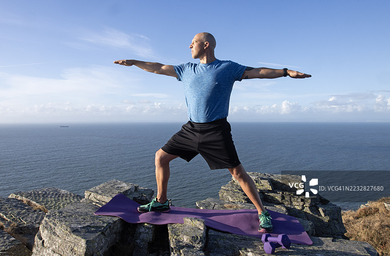 一名男子在埃克斯穆尔国家公园练习战士二式瑜伽体式图片素材