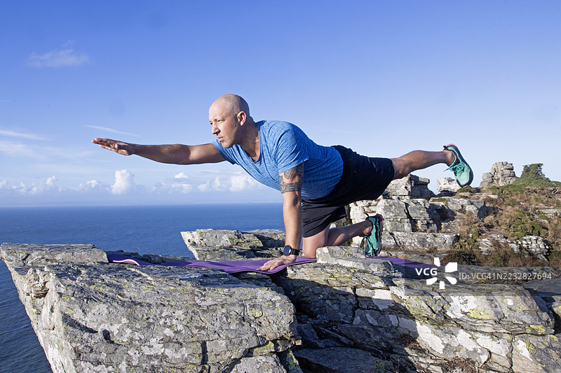 一名男子在埃克斯穆尔进行瑜伽“鸟狗式”体式图片素材