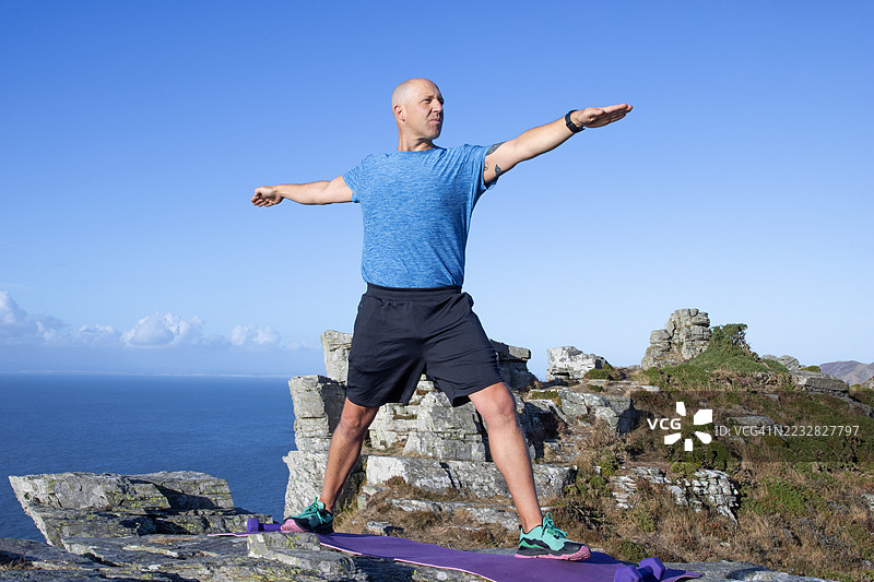 男子在埃克斯穆尔国家公园练习瑜伽“战士二式”图片素材