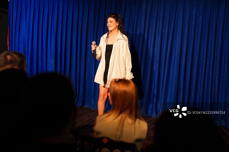 女性在舞台上用麦克风为观众表演图片素材