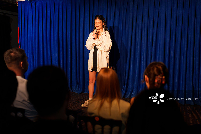 女性在舞台上用麦克风为观众表演图片素材