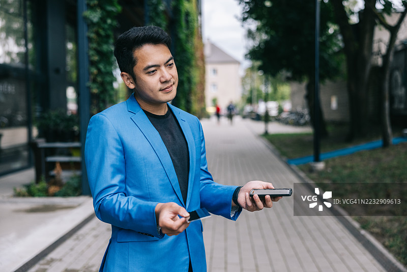 年轻的商人在城市户外对损坏的智能手机做出反应图片素材