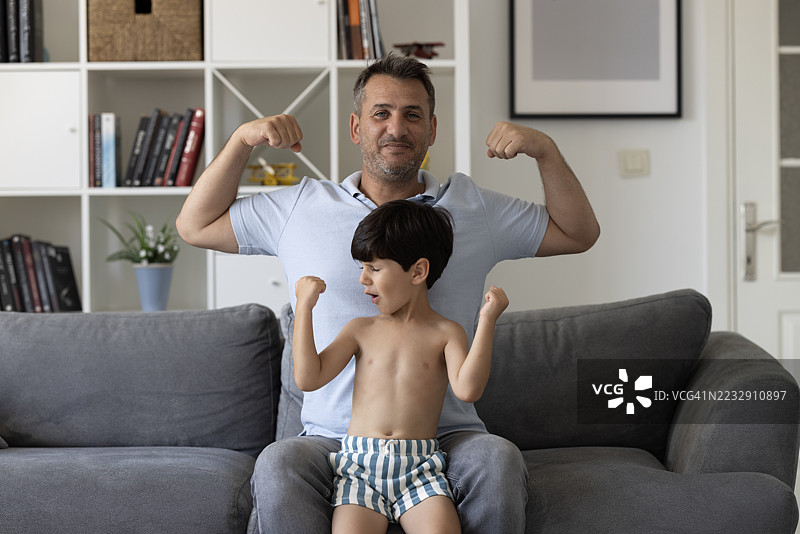 儿子展示肌肉和拳头力量训练图片素材