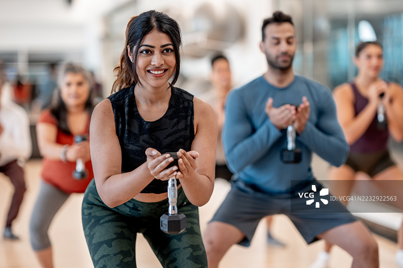 多样化的团体健身课程，使用哑铃进行力量训练图片素材