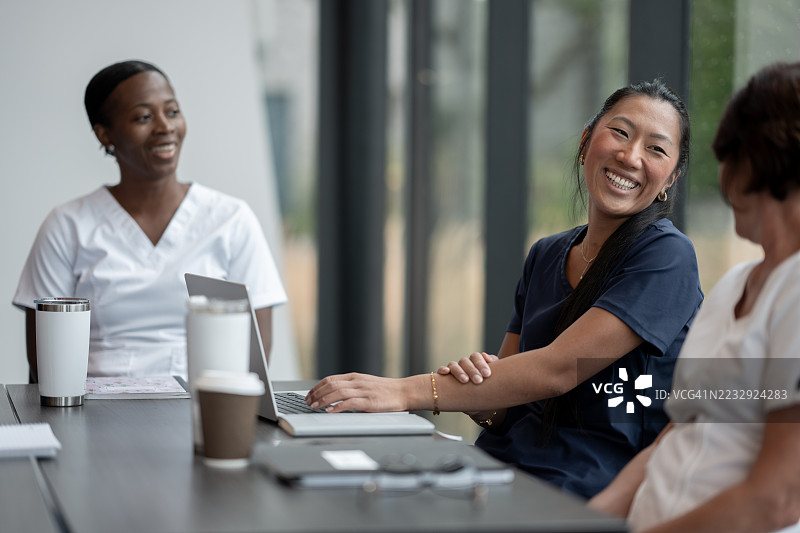 多元化的专业人士在现代办公室进行非正式讨论图片素材