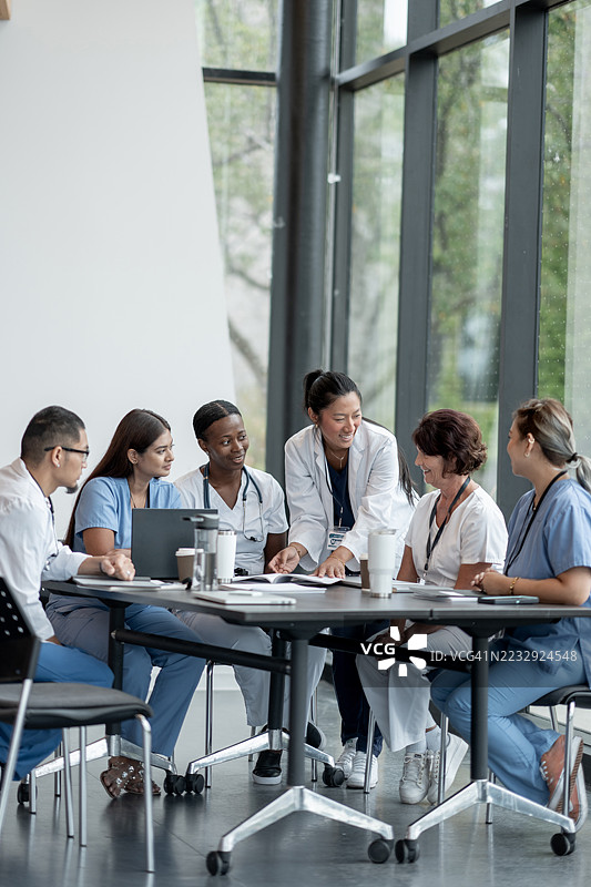 多元化的医疗专业人士在现代办公室环境中合作图片素材