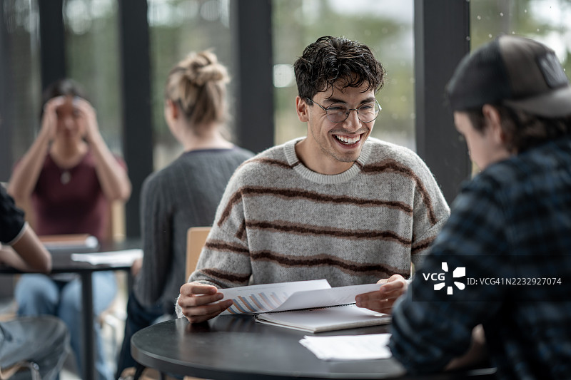 在咖啡馆里微笑的学生们一起学习讨论图片素材