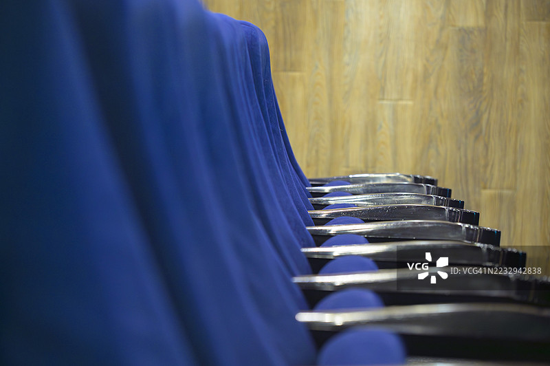 会议室里空荡荡的蓝色椅子在等待观众。图片素材