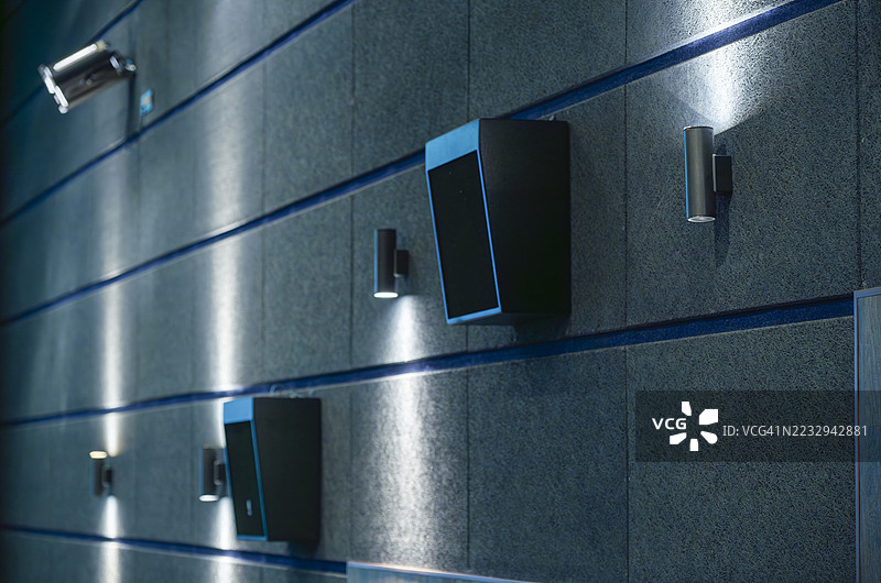 现代墙壁上悬挂的监控摄像头和扬声器图片素材