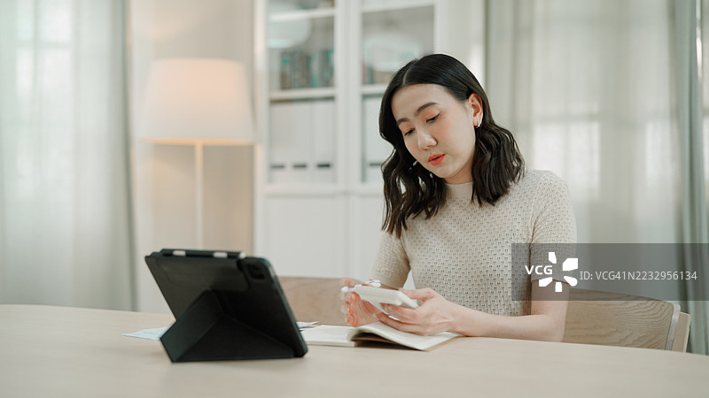 亚洲女性在家计算开支图片素材
