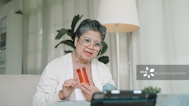 老年女性与医生在平板电脑上交谈图片素材