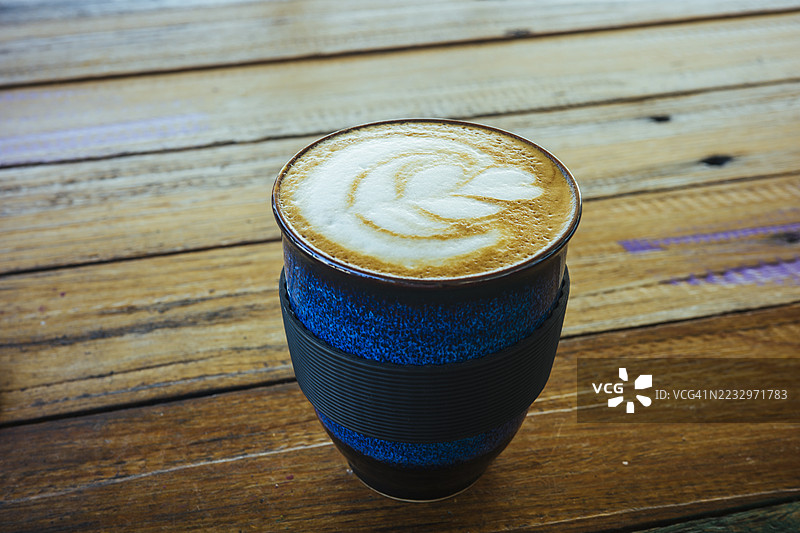复古木桌上的咖啡杯，拉花艺术精美图片素材