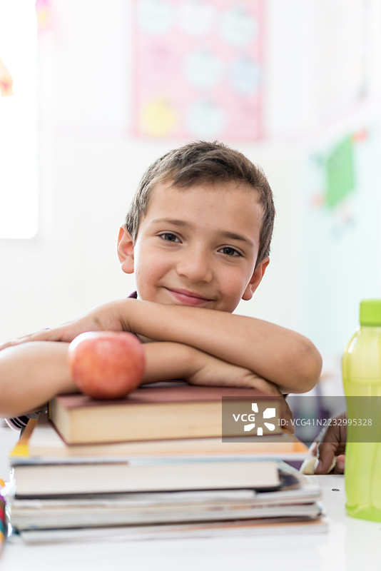 学生靠在教室里的书堆上图片素材