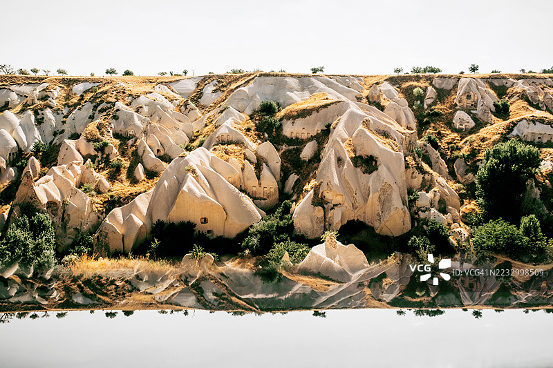 白色岩石形成与绿色树木。自然对称，反射，地质。图片素材