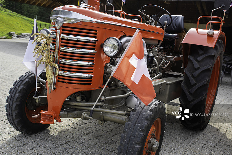 装饰有弗里堡和瑞士国旗以及麦穗花束的复古拖拉机图片素材