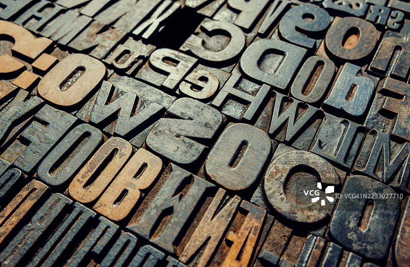 复古印刷块展示字母和数字，形成有纹理的背景图片素材