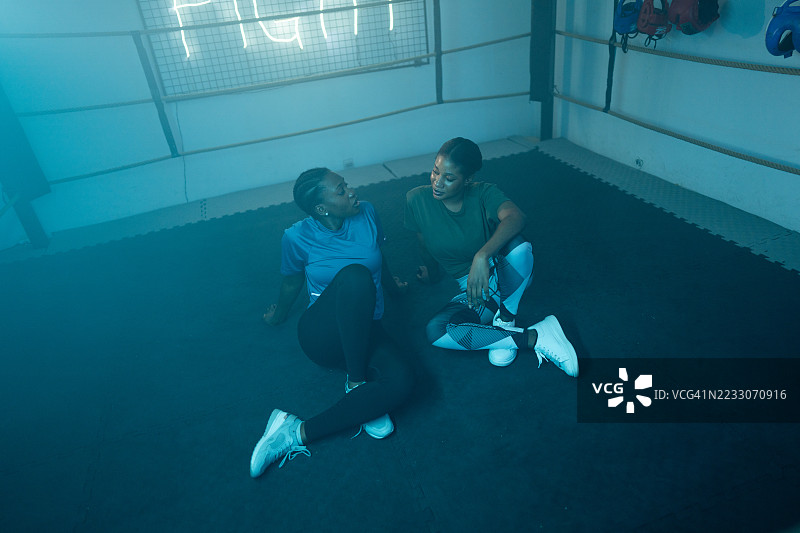 两位女性在健身房一起锻炼后放松休息图片素材