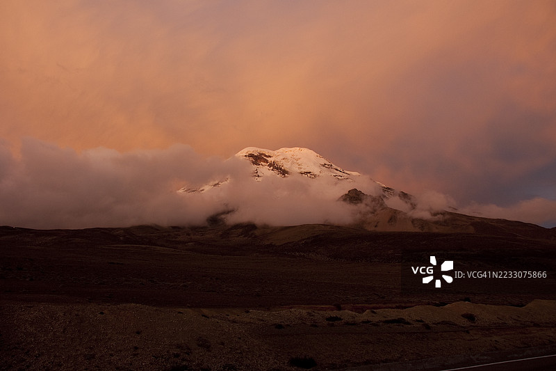 厄瓜多尔的钦博拉索火山在日落时分，云层覆盖着山顶。图片素材