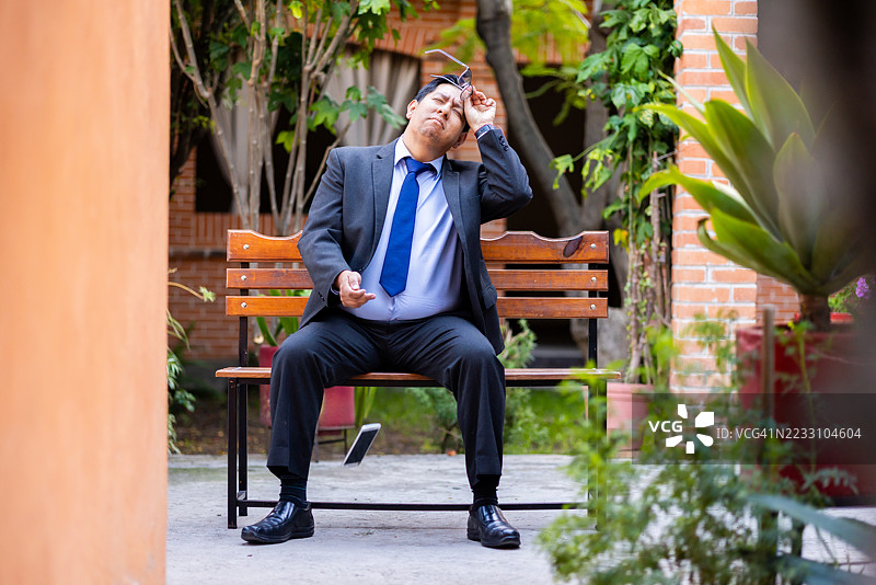 地板上放着一部坏掉的手机，一位商务人士图片素材