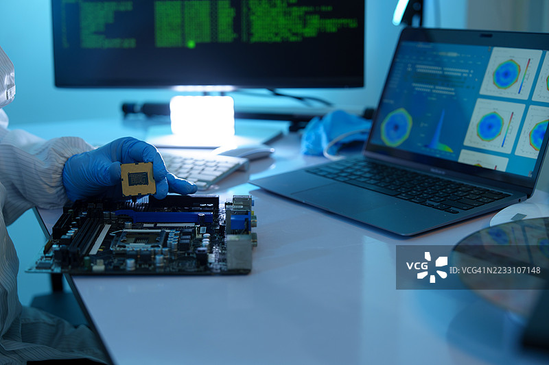 分析师在电子制造厂生产半导体。工人或工程师穿着医疗防护服或覆盖硅晶圆的白色长袍。图片素材