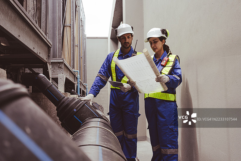 工程师正在检查大型工业建筑的水冷却塔空调，这是用于控制空气系统的水冷却塔空气冷却器HVAC。图片素材