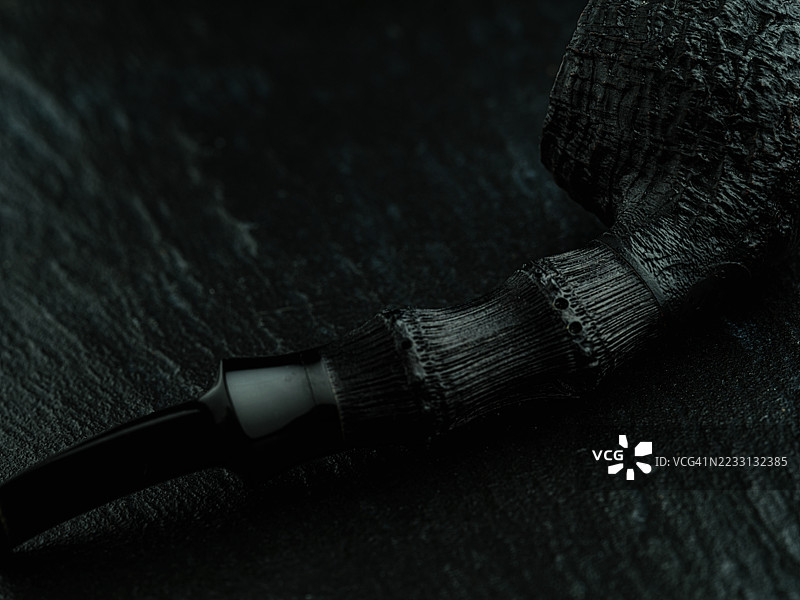 一款全黑的喷砂烟斗，设计简约流畅，配有黑色竹制烟杆，增添了精致自然的触感。图片素材