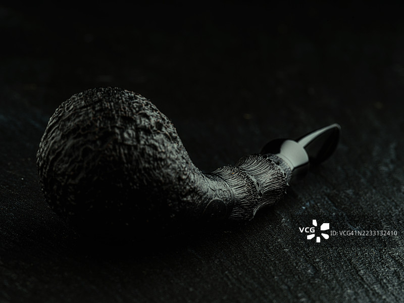 一款全黑的喷砂烟斗，设计简约流畅，配有黑色竹制烟杆，增添了精致自然的气息。图片素材