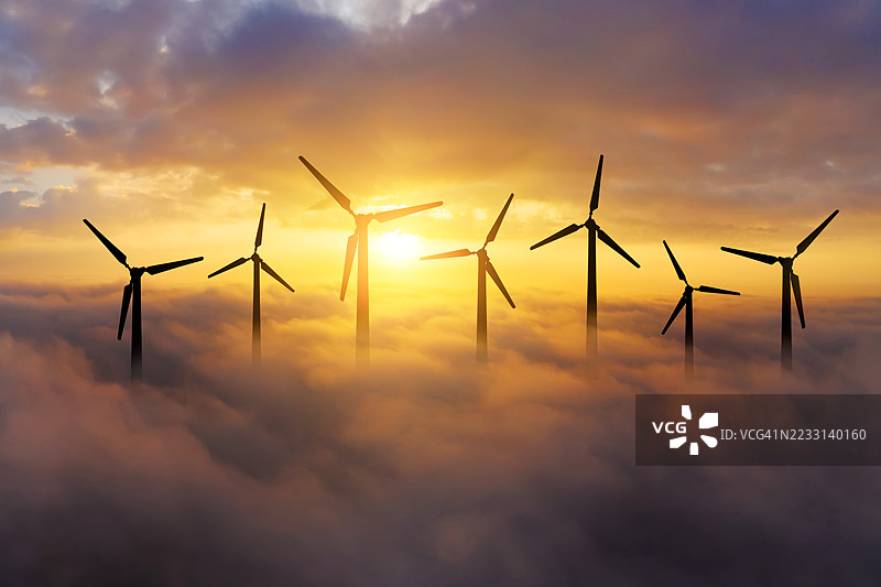 日落时分云中的风力涡轮机图片素材