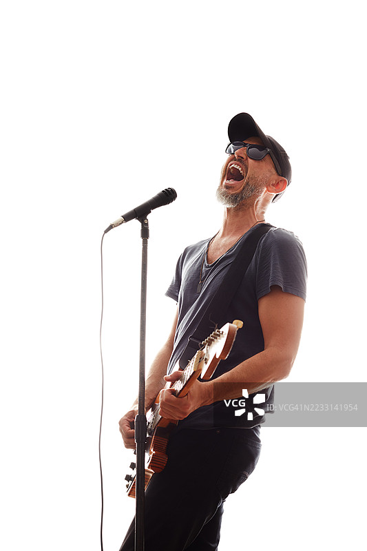 摇滚音乐家激情四溢地演唱，尽情地在电吉他上演奏。图片素材