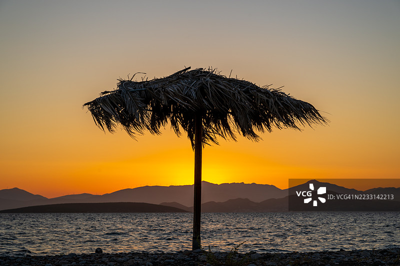 日落后的沙滩伞剪影图片素材