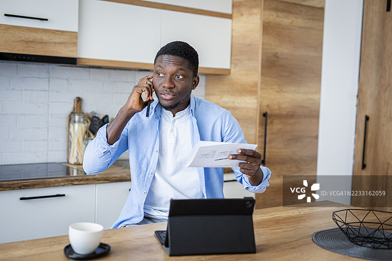 男人在家厨房里处理财务账单图片素材