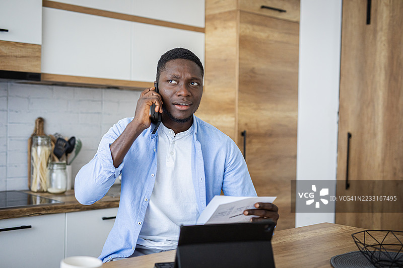 男人在家厨房里处理财务账单图片素材