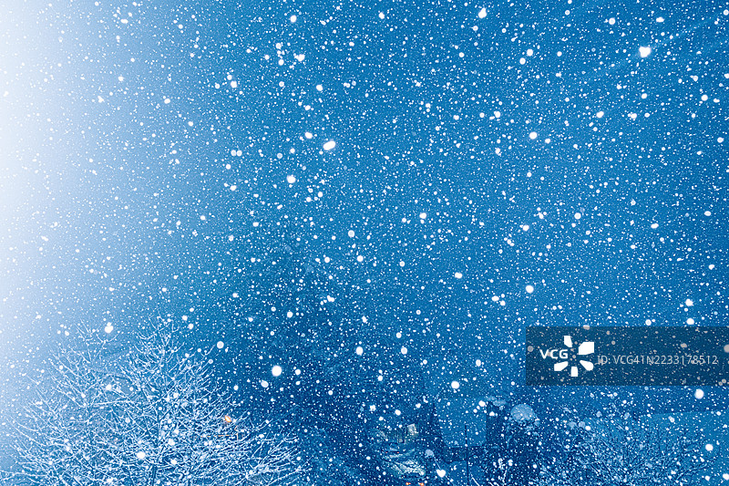 抽象蓝色散景背景与飘落雪花效果图片素材