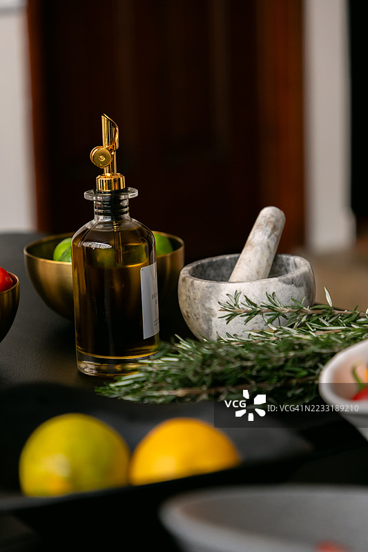 新鲜的迷迭香、柠檬、青柠、辣椒和橄榄油准备好用于制作地中海餐。图片素材