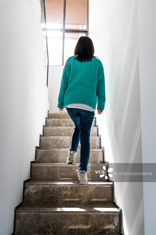 女人在家中走上楼梯图片素材