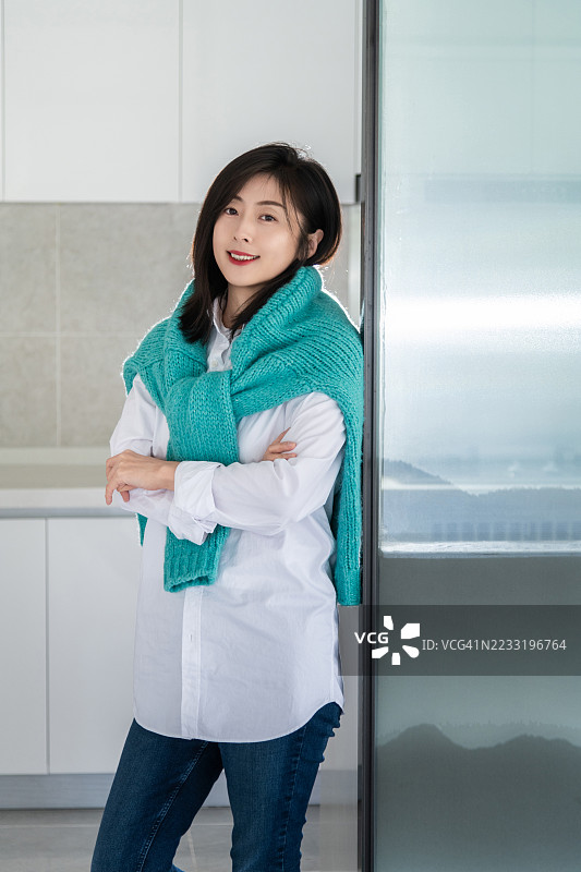 一位自信快乐的美丽女性站在她的厨房里图片素材