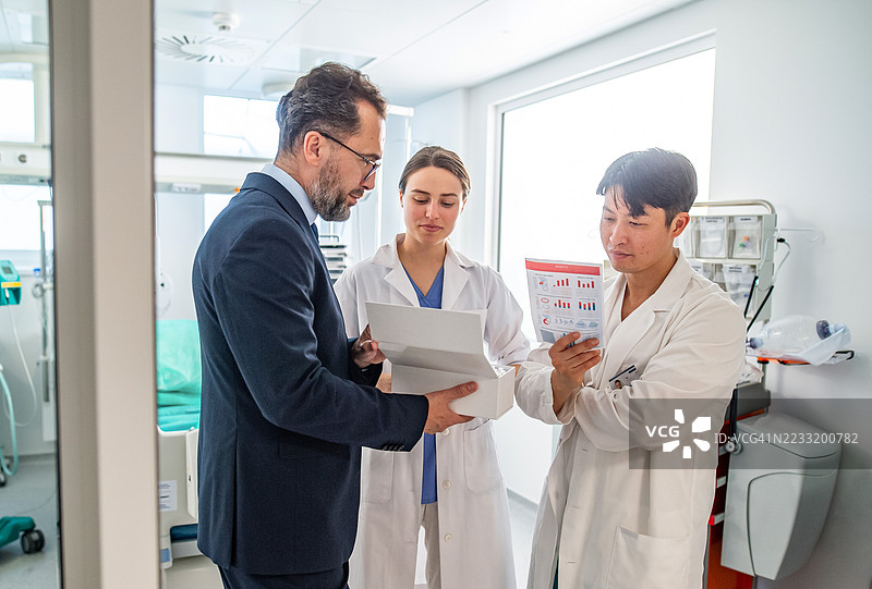 医生们在查看由制药销售代表提供的新药物盒。图片素材