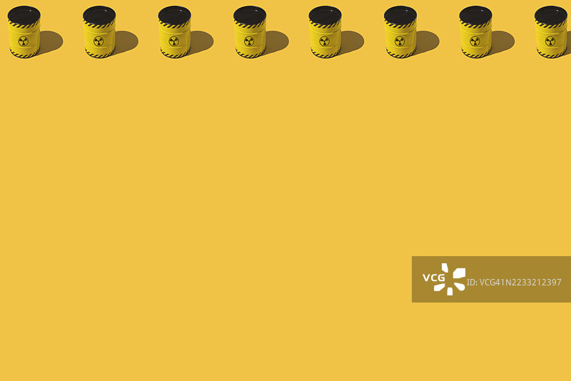 黄色金属桶和核符号的图案，位于黄色背景上。能源、供应、灾难、斗争、对抗、化学武器、战争、危险和切尔诺贝利图片素材