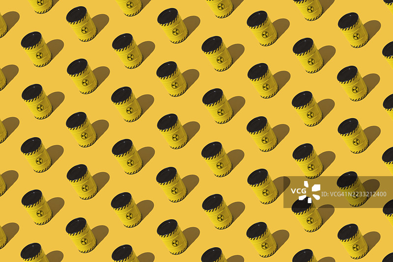 黄色背景上有黄色金属桶和核符号的图案。能源、供应、灾难、斗争、对抗、化学武器、战争、危险和切尔诺贝利。图片素材