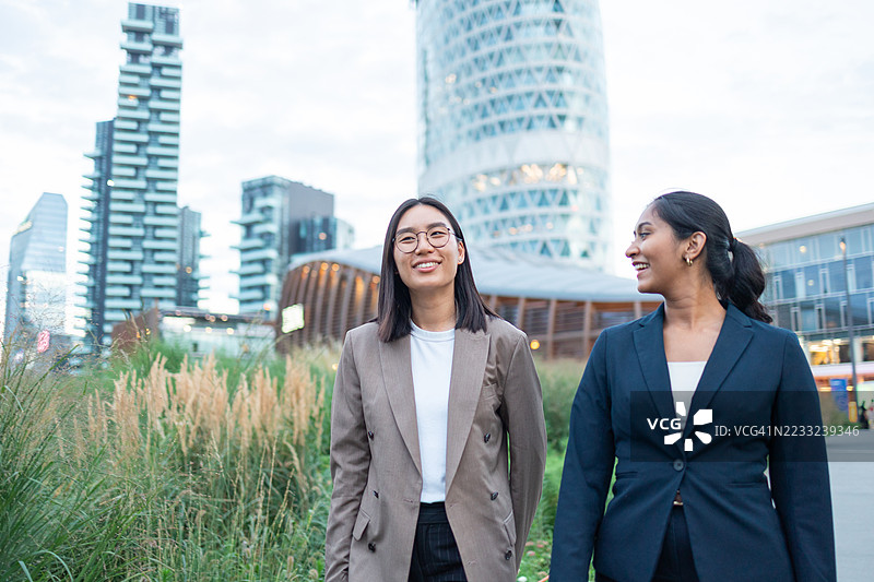 两位年轻女商人在意大利米兰边走边谈图片素材