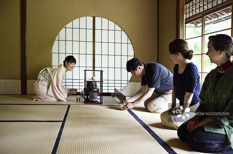 男子在茶道中捧起茶碗图片素材