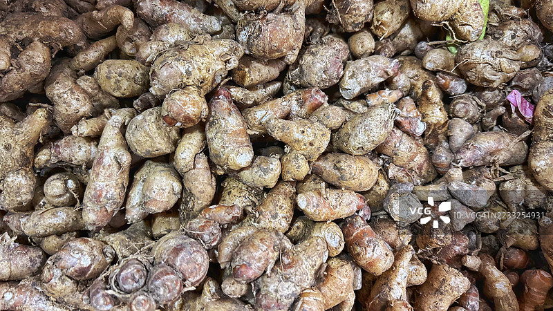 新鲜的香根草块茎特写，堆放在市场上，传统草药香料背景，完美适合烹饪、健康和农业概念图片素材