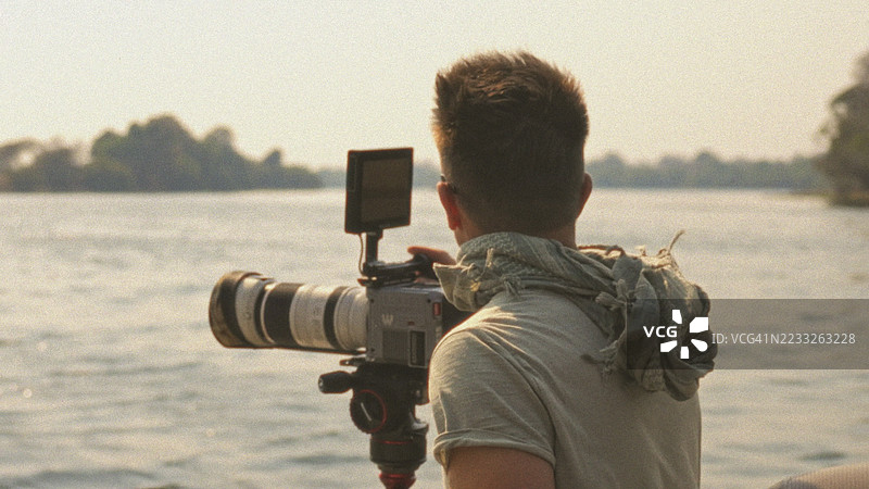 摄影师用专业相机拍摄风景如画的河流景观图片素材