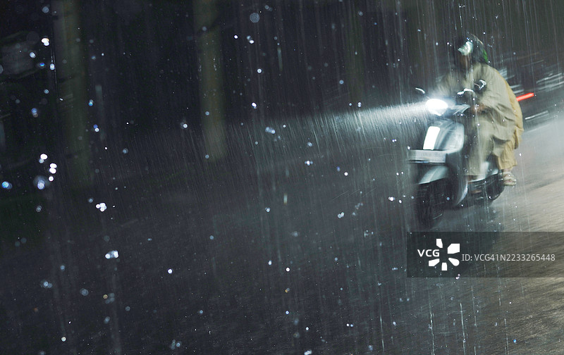 在雅加达的大雨中骑摩托车图片素材