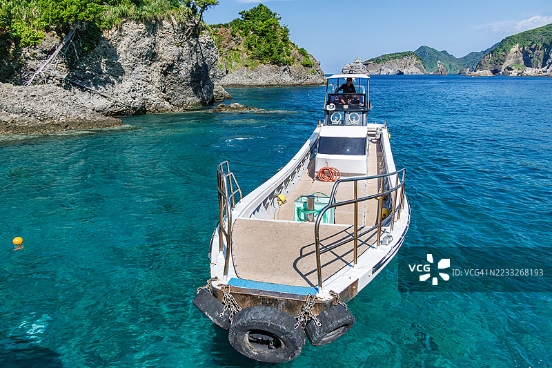 照片展示了当天第一艘船离开中木港前往平藏海滩。浮潜者和潜水者在等待登船的机会。平藏海滩，中木港，南伊豆。图片素材