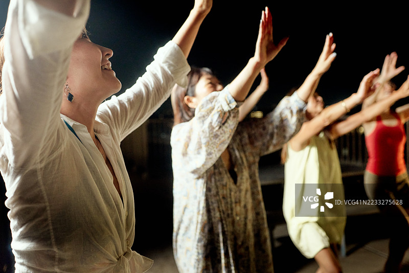 一群朋友在夏季傍晚的屋顶露台上享受饮品和美食图片素材