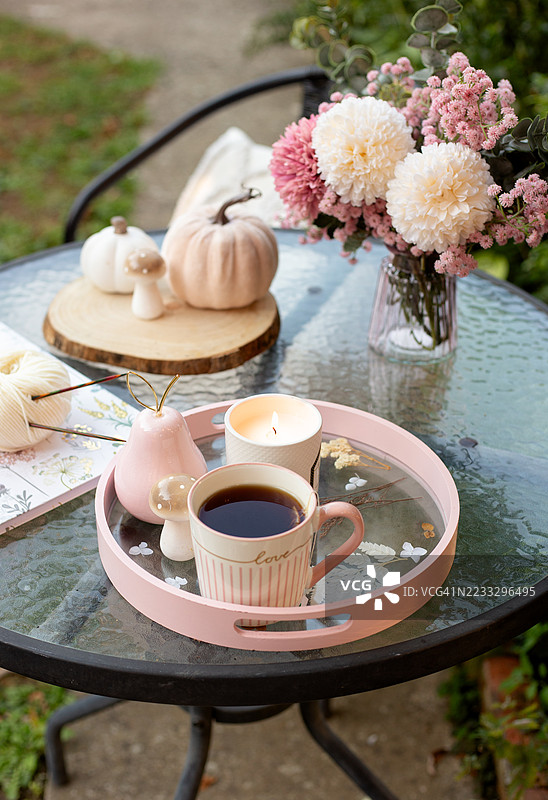 温馨的秋季氛围，手工编织的帽子、南瓜、多彩的树叶和季节性花卉。完美适合秋天、万圣节和温暖的手工针织时光。图片素材