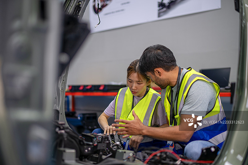 机械师在电动车维修车间工作。图片素材