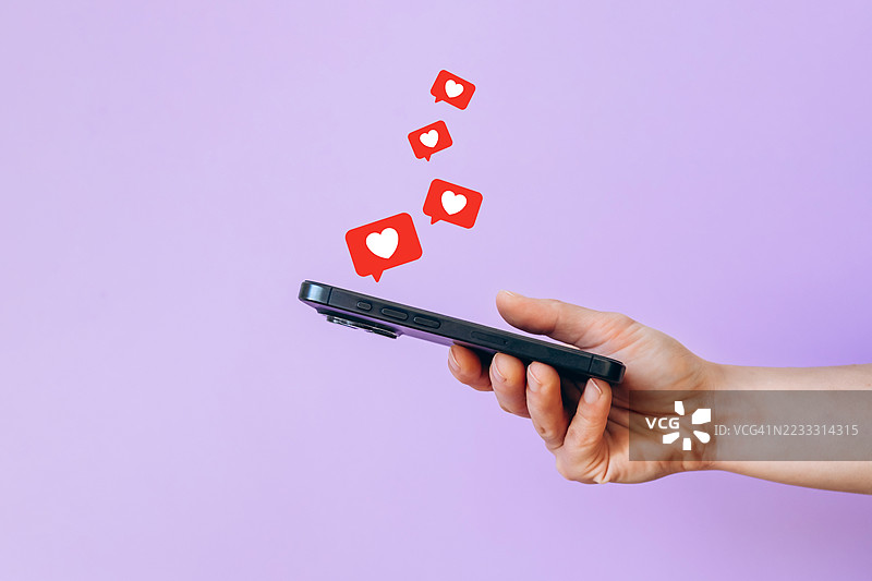 女性手持手机，背景为薰衣草色，显示许多社交媒体点赞。图片素材