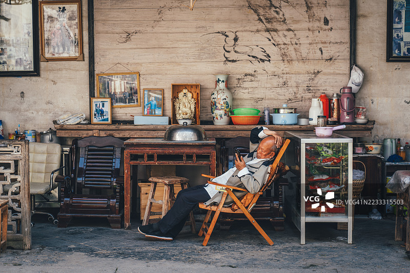 在中国安徽黄山的卢村，老人在传统环境中放松。图片素材